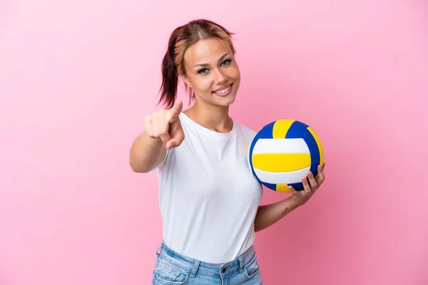 年轻的俄罗斯女子打排球时 背景是粉色的 面带微笑地朝前看 — 图库照片
