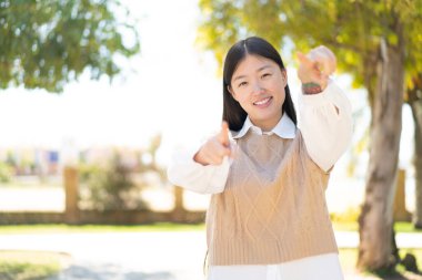 Dışarıdaki güzel Çinli kadın gülümserken seni işaret ediyor.