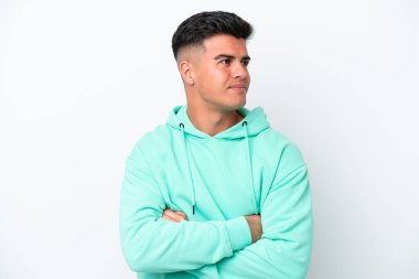 Beyaz arka planda soyutlanmış beyaz tenli yakışıklı bir adam yan tarafa bakıyor.