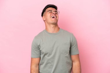 Beyaz tenli yakışıklı adam pembe arka planda izole edilmiş gülüyor.