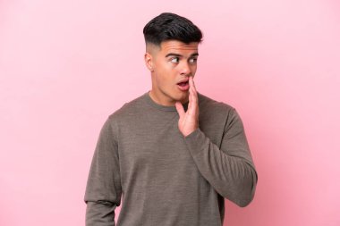 Pembe arka planda izole edilmiş beyaz yakışıklı bir adam. Yan tarafa bakarken sürpriz bir jest yapıyor.