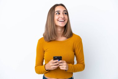 Beyaz arka planda izole genç beyaz kadın cep telefonu kullanarak ve yukarı bakarak