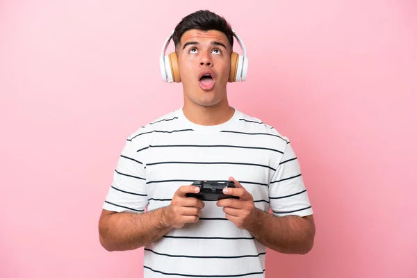 Νεαρός Όμορφος Άνδρας Παίζει Ένα Χειριστήριο Βιντεοπαιχνιδιών Απομονωμένος Ροζ Φόντο — Φωτογραφία Αρχείου