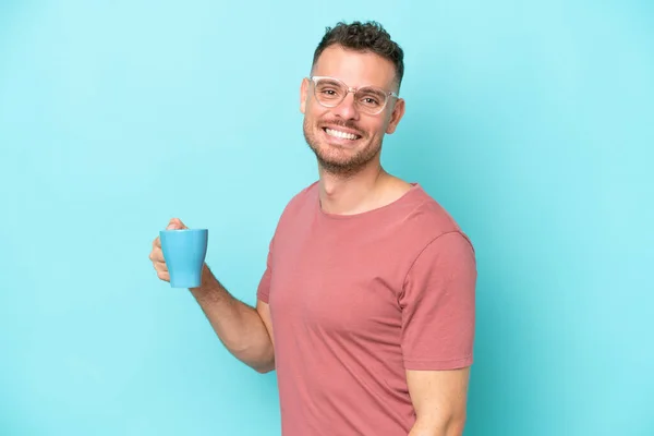 Jonge Blanke Man Met Kopje Koffie Geïsoleerd Blauwe Achtergrond Glimlachen — Stockfoto