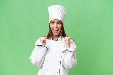 Genç aşçı Kafkas kadın tecrit edilmiş arka planda galibiyeti kutluyor.