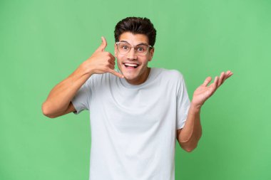 Kafkasyalı yakışıklı bir adam izole edilmiş arka planda telefon jesti yapıyor.