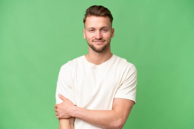 Sarışın, beyaz, soyutlanmış bir geçmişi olan bir adam gülüyor.