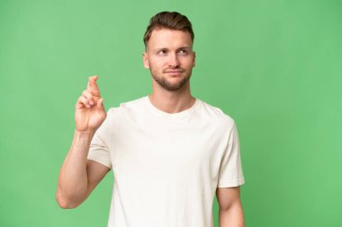 Sarışın, beyaz tenli, izole bir geçmişi olan, parmaklarını çapraz yapıp en iyisini dileyen bir adam.