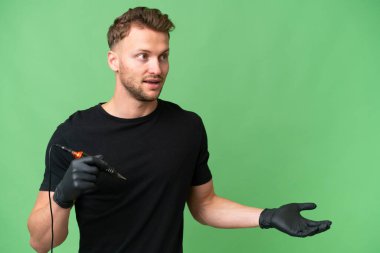 Dövme sanatçısı Kafkasyalı bir adam, yan bakarken sürpriz bir ifadeyle izole edilmiş arkaplanda