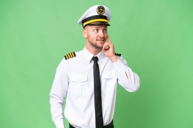 Uçak pilotu arka planda izole edilmiş bir şekilde yukarı bakarken bir fikir düşünüyor.