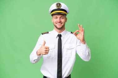 Uçak pilotu izole edilmiş arka planda işaret ve baş parmak hareketi gösteriyor.