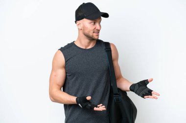 İzole edilmiş beyaz bir arka planı olan beyaz spor çantalı, sarışın, beyaz, beyaz bir erkek. Yüz ifadesi şaşırtıcıydı.