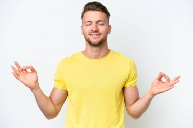 Zen pozisyonunda beyaz arka planda izole edilmiş genç sarışın beyaz adam.