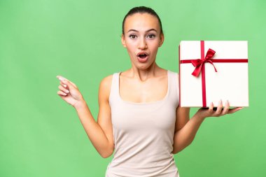 Genç bir Arap kadının, izole edilmiş bir geçmişi var. Şaşırmış ve işaret ediyor.