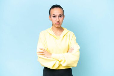 Genç bir Arap kadını mavi arka planda mahsur kaldı.