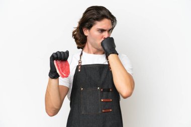 Önlük takan yakışıklı kasap beyaz arka planda izole edilmiş taze et servis ediyor.