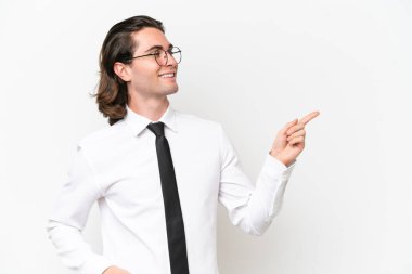 Beyaz arka planda izole edilmiş yakışıklı bir iş adamı, parmağını yana uzatarak bir ürün sunuyor.