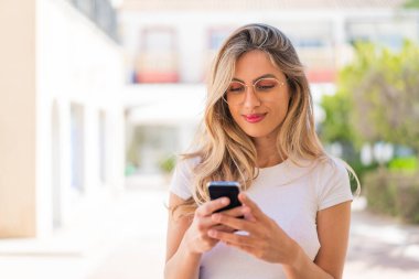 Güzel sarışın Uruguaylı kadın cep telefonu kullanıyor.