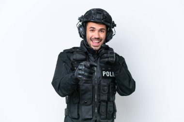 Beyaz arka planda izole edilmiş beyaz önü işaret eden ve gülümseyen Kafkasyalı genç SWAT adamı.