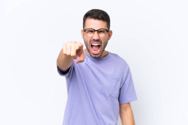 Beyaz arka planda izole edilmiş genç beyaz adam hayal kırıklığına uğramış ve ön tarafı işaret ediyor.