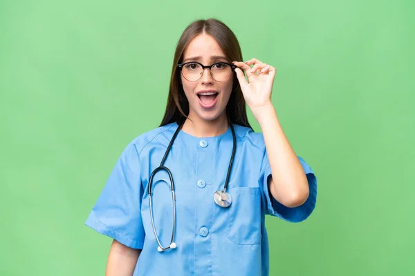 stock image Young nurse caucasian woman over isolated background with glasses and surprised