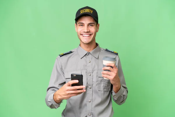 Mladý Bezpečnostní Muž Přes Izolované Pozadí Drží Kávu Aby Pryč — Stock fotografie