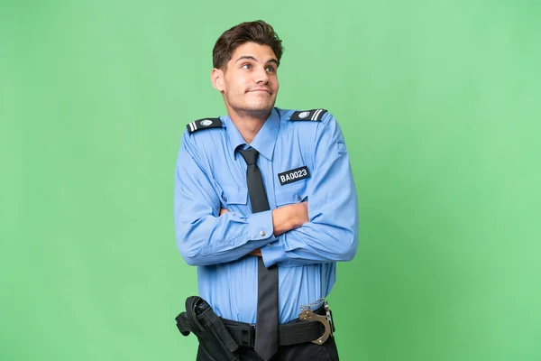 Młody Policjant Odosobnionym Pochodzeniem Robi Gest Wątpliwości Podnosząc Ramiona — Zdjęcie stockowe
