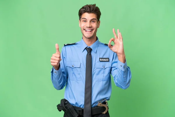 stock image Young police man over isolated background showing ok sign and thumb up gesture
