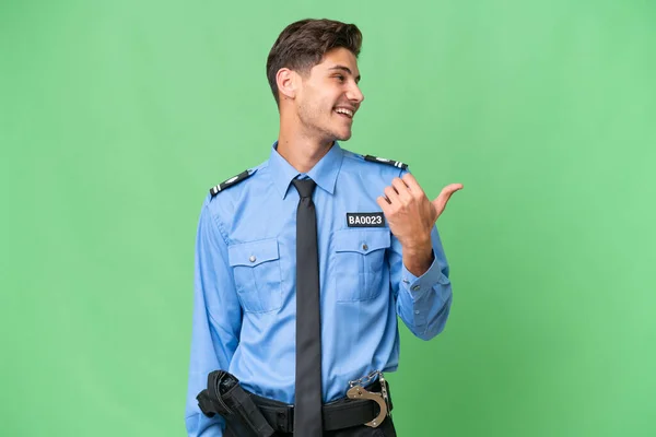 Jonge Politieman Geïsoleerde Achtergrond Wijst Naar Zijkant Een Product Presenteren — Stockfoto