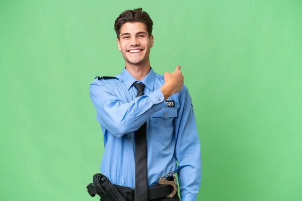 Молодий Поліцейський Над Ізольованим Тлом Вказує Назад — стокове фото