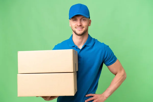 Delivery Caucasian Man Isolated Background Posing Arms Hip Smiling — Stock Photo, Image