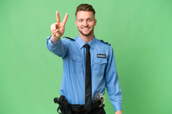 Jonge Politieman Geïsoleerde Achtergrond Glimlachen Tonen Overwinning Teken — Stockfoto