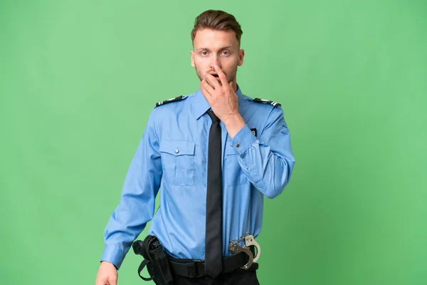 Młody Policjant Odizolowanym Tle Zaskoczony Zszokowany Patrząc Prawo — Zdjęcie stockowe