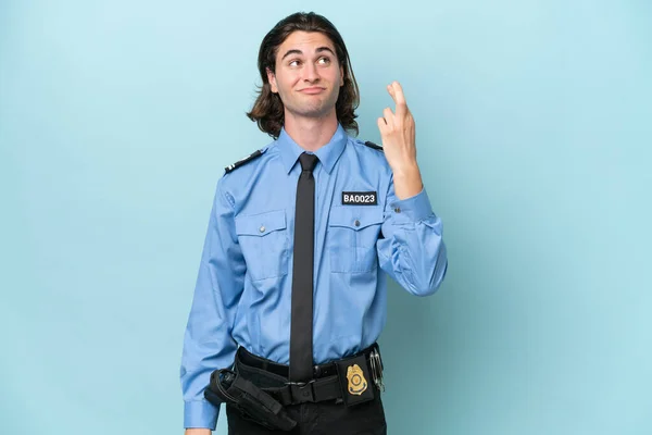 Молодий Поліцейський Білий Чоловік Ізольований Синьому Фоні Пальцями Перетинаються Бажають — стокове фото