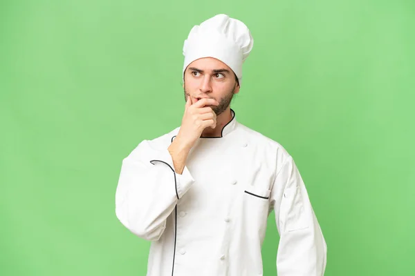 Jovem Bonito Chef Homem Sobre Isolado Fundo Tendo Dúvidas Com — Fotografia de Stock
