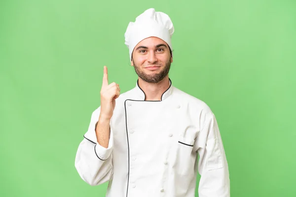 Mladý Pohledný Kuchař Muž Přes Izolované Pozadí Ukazuje Ukazováčkem Skvělý — Stock fotografie