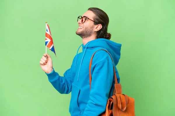 年轻英俊的男子举着英国国旗 在孤立的背景下 侧身笑着 — 图库照片