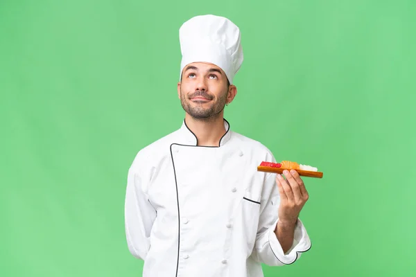 Jeune Chef Caucasien Tenant Sushi Sur Fond Isolé Levant Les — Photo