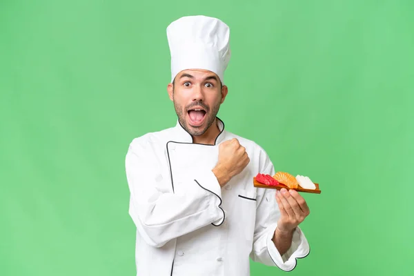 Joven Chef Caucásico Sosteniendo Sushi Sobre Fondo Aislado Celebrando Una — Foto de Stock