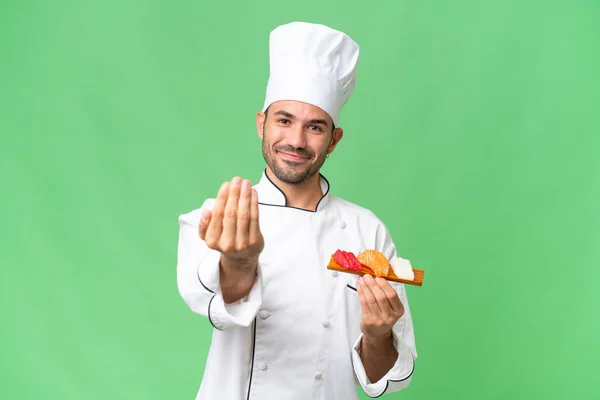 Jeune Chef Caucasien Tenant Sushi Sur Fond Isolé Invitant Venir — Photo
