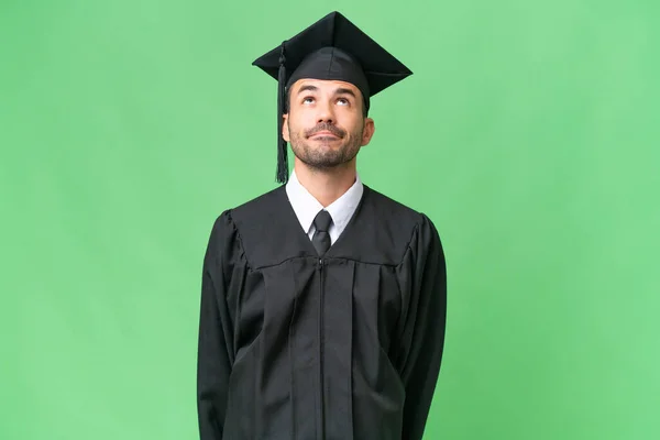 Fiatal Egyetemi Diplomás Férfi Elszigetelt Háttér Felnézett — Stock Fotó