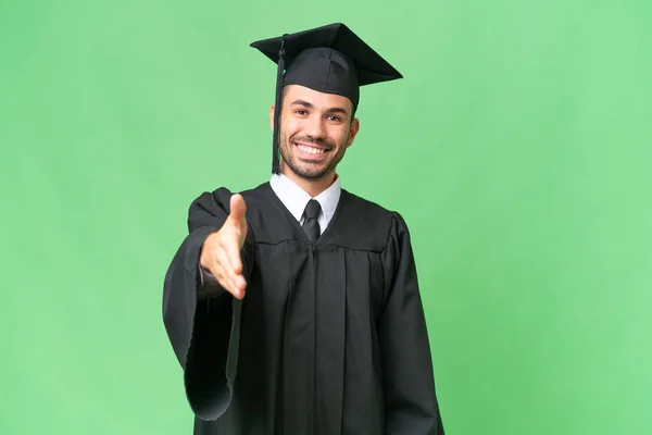 Jovem Universitário Graduado Homem Sobre Isolado Fundo Apertando Mãos Para — Fotografia de Stock
