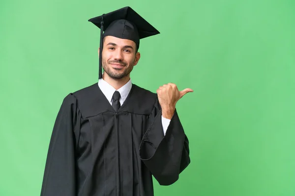 Νεαρός Απόφοιτος Πανεπιστημίου Άνθρωπος Πάνω Από Απομονωμένο Υπόβαθρο Που Δείχνει — Φωτογραφία Αρχείου