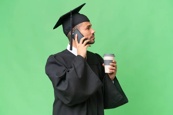 Üniversite Mezunu Genç Bir Adam Izole Edilmiş Arka Planda Kahve — Stok fotoğraf