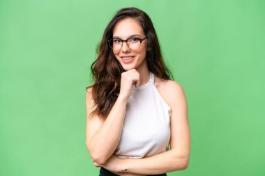 Kafkasyalı genç bir kadın izole edilmiş arka planda gözlüklü ve gülümseyen