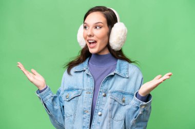 İzole edilmiş arka planda kışın kuklalar takan beyaz bir kadın. Şaşırtıcı bir yüz ifadesi var.