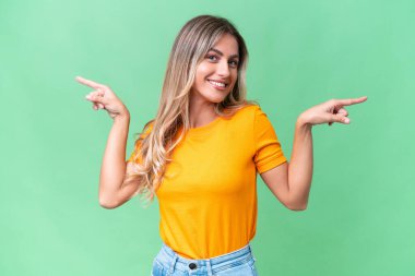 Genç Uruguaylı kadın izole edilmiş arka planda işaret ediyor ve mutlu.