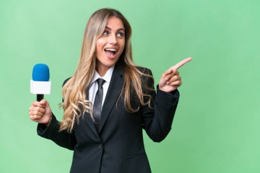 Genç, güzel Uruguaylı televizyon sunucusu, izole edilmiş arka plan üzerinde parmağını kaldırarak çözümü anlamaya çalışıyor.