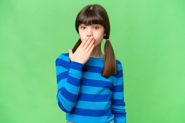 İzole edilmiş arka planda küçük beyaz kız ağızlarını eliyle kapatıyor.