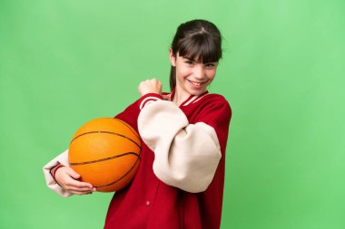 İzole edilmiş arka planda basketbol oynayan küçük beyaz kız gururlu ve kendini beğenmiş.